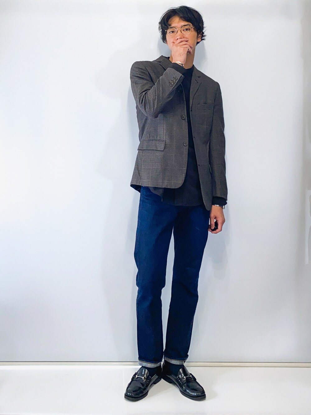 グレー系のテーラードジャケット、ブラック系のシャツ/ブラウス、ブルー系のデニムパンツを着用したメンズの冬コーディネートの1枚目の写真