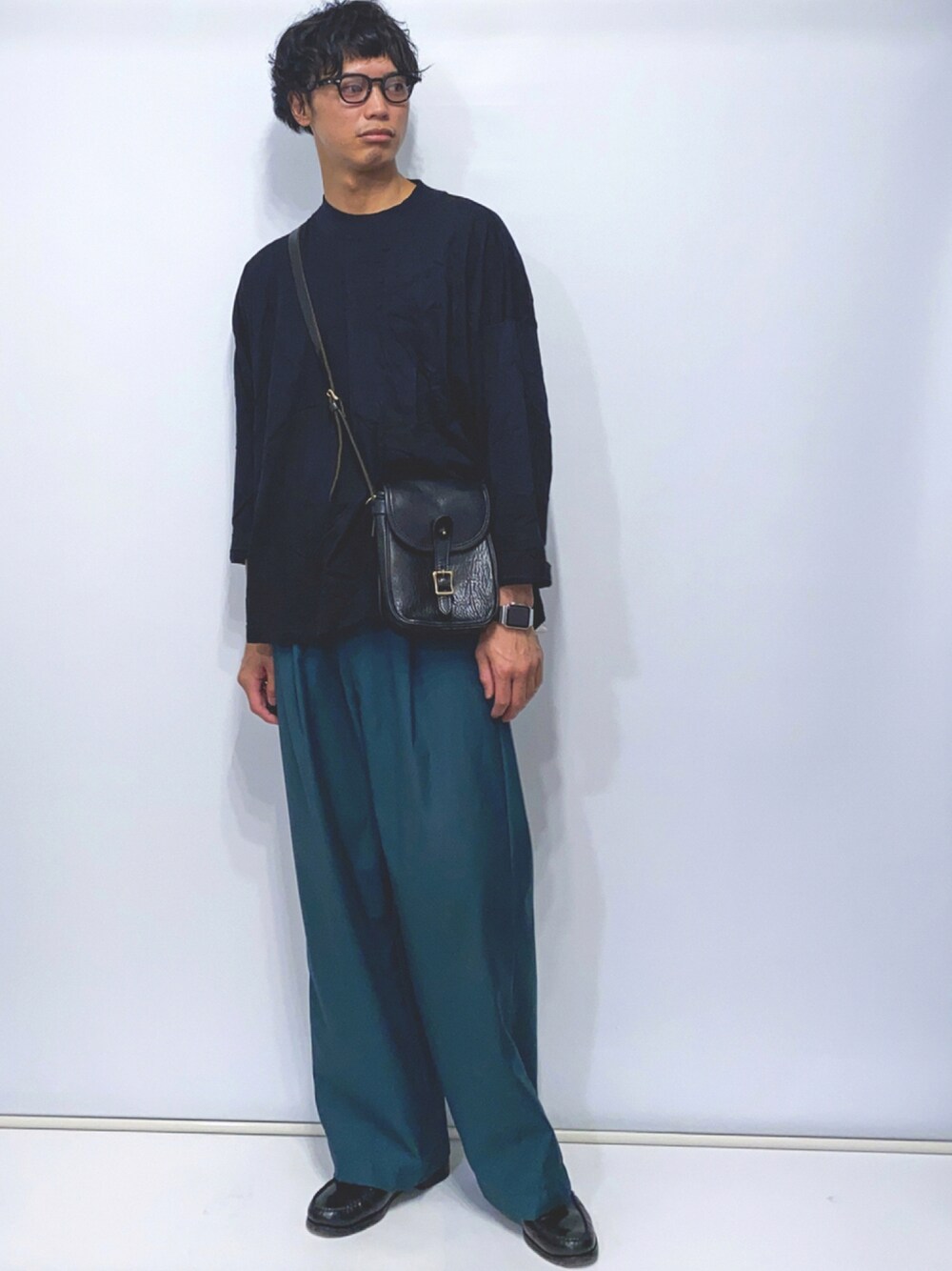 ブラック系のTシャツ/カットソー、ブラック系のショルダーバッグ、グリーン系のスラックスを着用したメンズの秋コーディネートの1枚目の写真