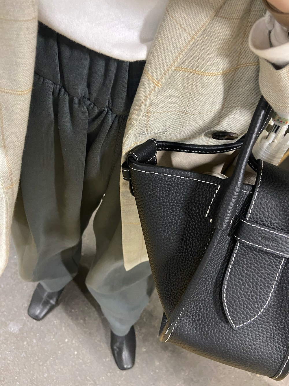 ブラック系のブーツ、グリーン系のスウェットパンツ、ベージュ系のジャケット/アウターを着用したレディースの春コーディネートの1枚目の写真