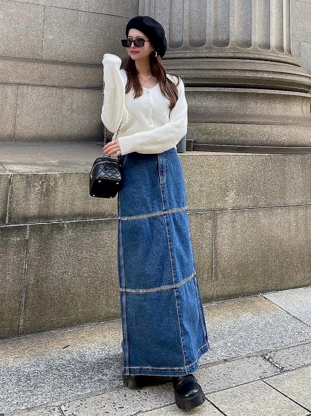 ブルー系のデニムスカート、ホワイト系のニット/セーターを着用したレディースの秋コーディネートの1枚目の写真