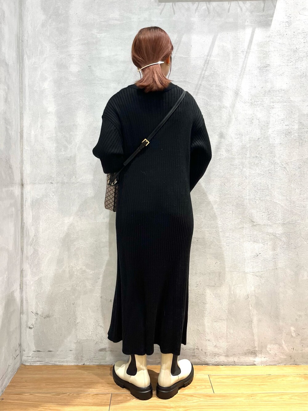 ホワイト系のブーツ、ブラック系のワンピース、ブラック系のショルダーバッグを着用したレディースの冬コーディネートの2枚目の写真