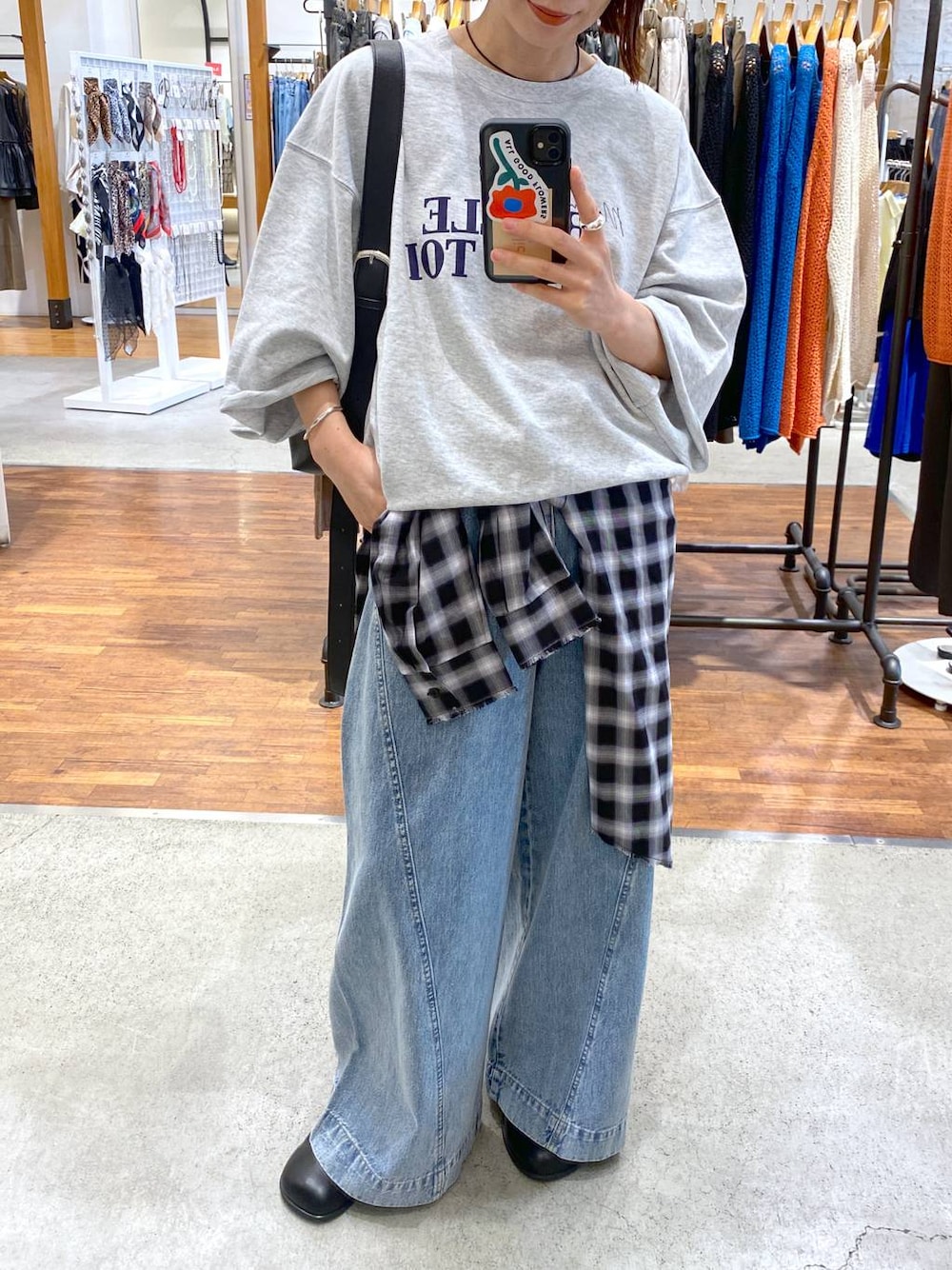 ブルー系のデニムパンツ、ブラック系のショルダーバッグ、ブラック系のその他シューズを着用したレディースの秋コーディネートの1枚目の写真