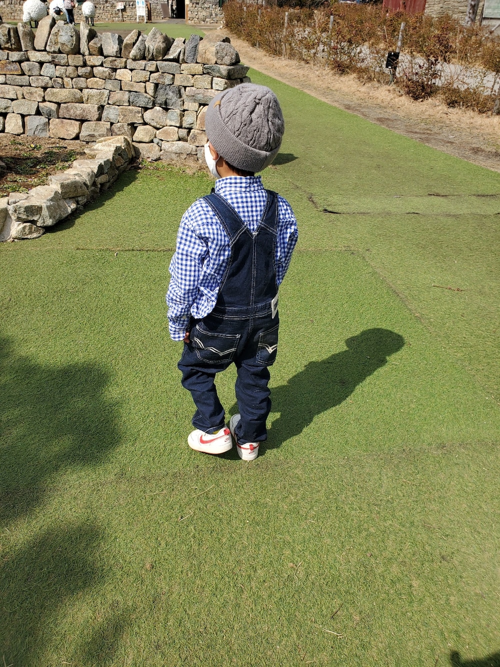 ブルー系のサロペット/オーバーオール、ホワイト系の蝶ネクタイを着用したキッズの春コーディネートの2枚目の写真