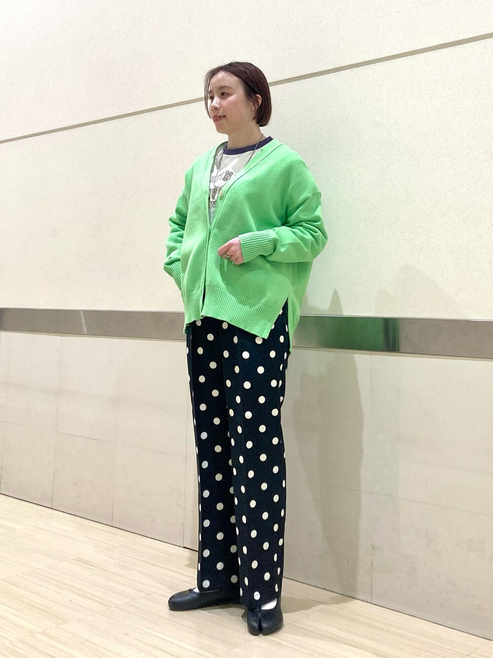 グリーン系のカーディガン/ボレロ、ブラック系のその他パンツ、パープル系のTシャツ/カットソーを着用したレディースの春コーディネートの1枚目の写真