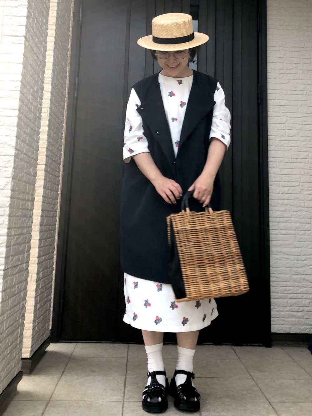 ホワイト系のワンピース/ドレス、ブラウン系のバッグ、ブラック系のサンダルを着用したレディースの夏コーディネートの1枚目の写真