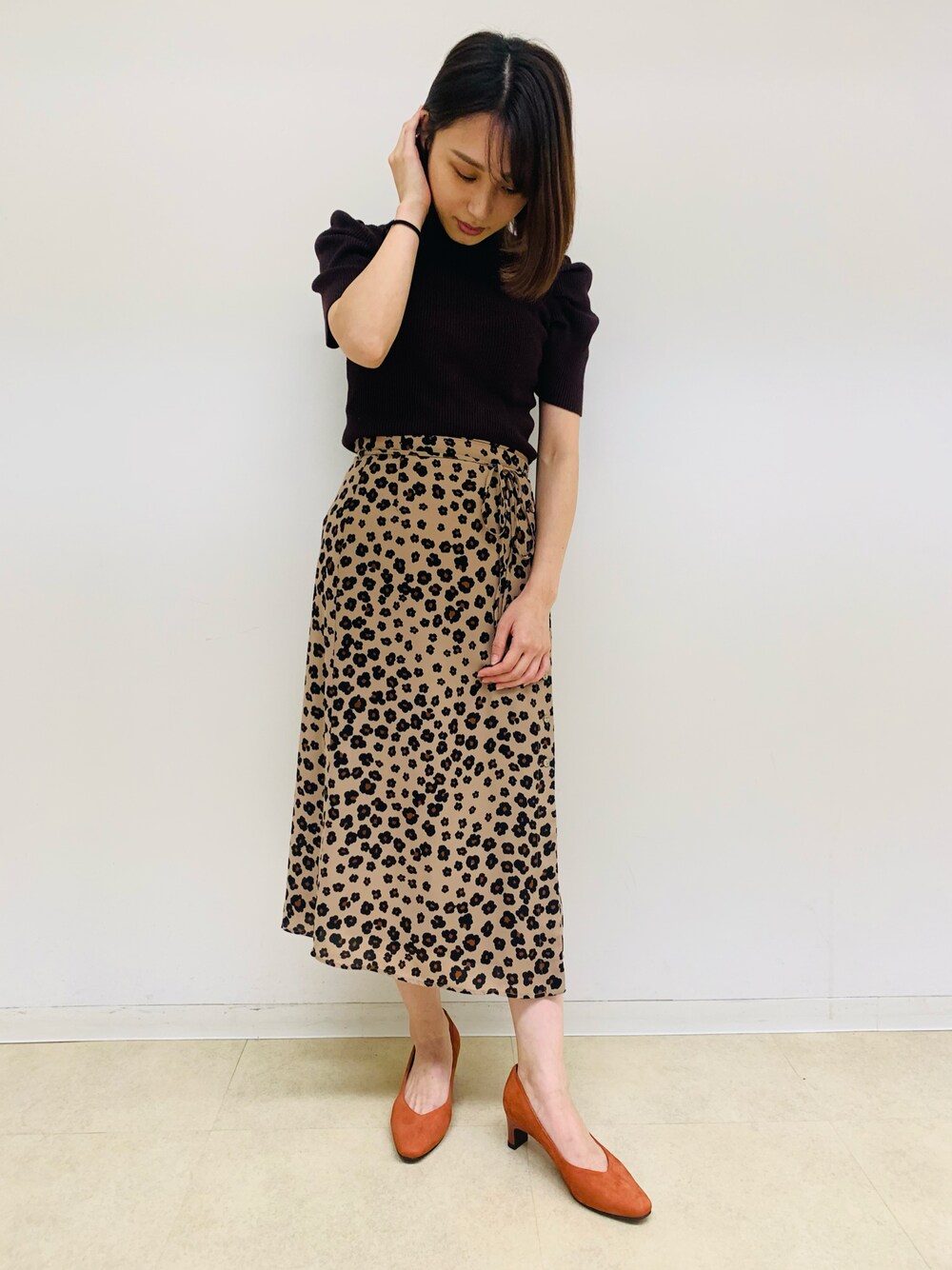 オレンジ系のパンプス、その他のスカート、ブラウン系のニット/セーターを着用したレディースの夏コーディネートの1枚目の写真