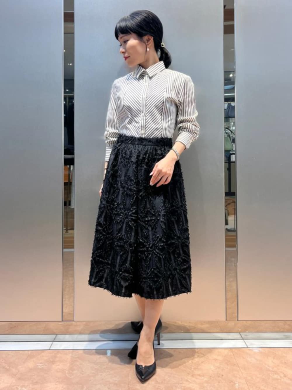 ブラック系のスカート、ブラック系のシャツ/ブラウスを着用したレディースの秋コーディネートの1枚目の写真