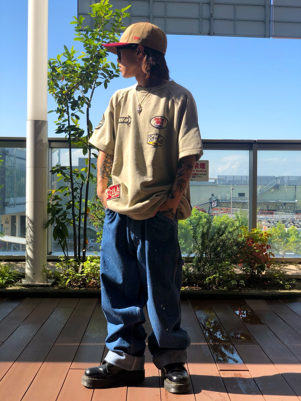 ベージュ系のTシャツ/カットソー、ブルー系のデニムパンツ、ブラウン系のキャップを着用したメンズの夏コーディネートの1枚目の写真