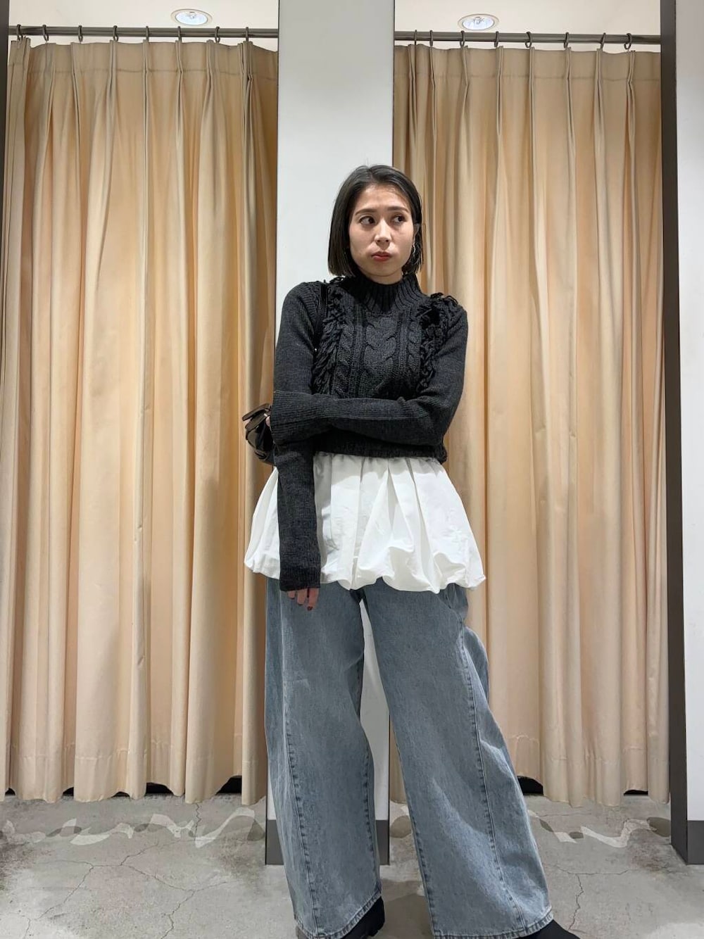 ブルー系のデニムパンツ、ホワイト系のカーディガン/ボレロ、グレー系のニット/セーターを着用したレディースの冬コーディネートの1枚目の写真