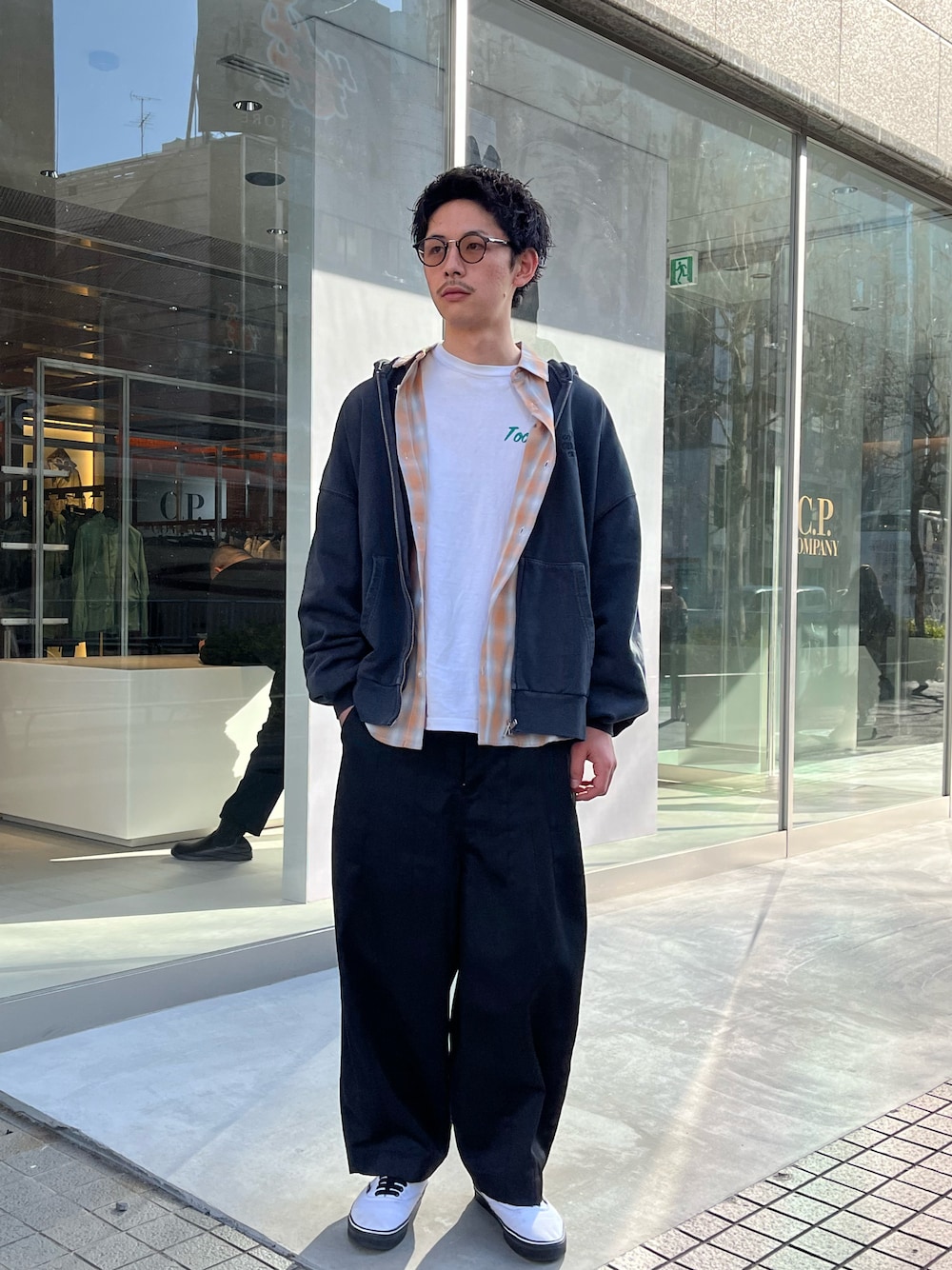 オレンジ系のシャツ/ブラウス、グレー系のパーカー、ブラック系のチノパンツを着用したメンズの春コーディネートの1枚目の写真