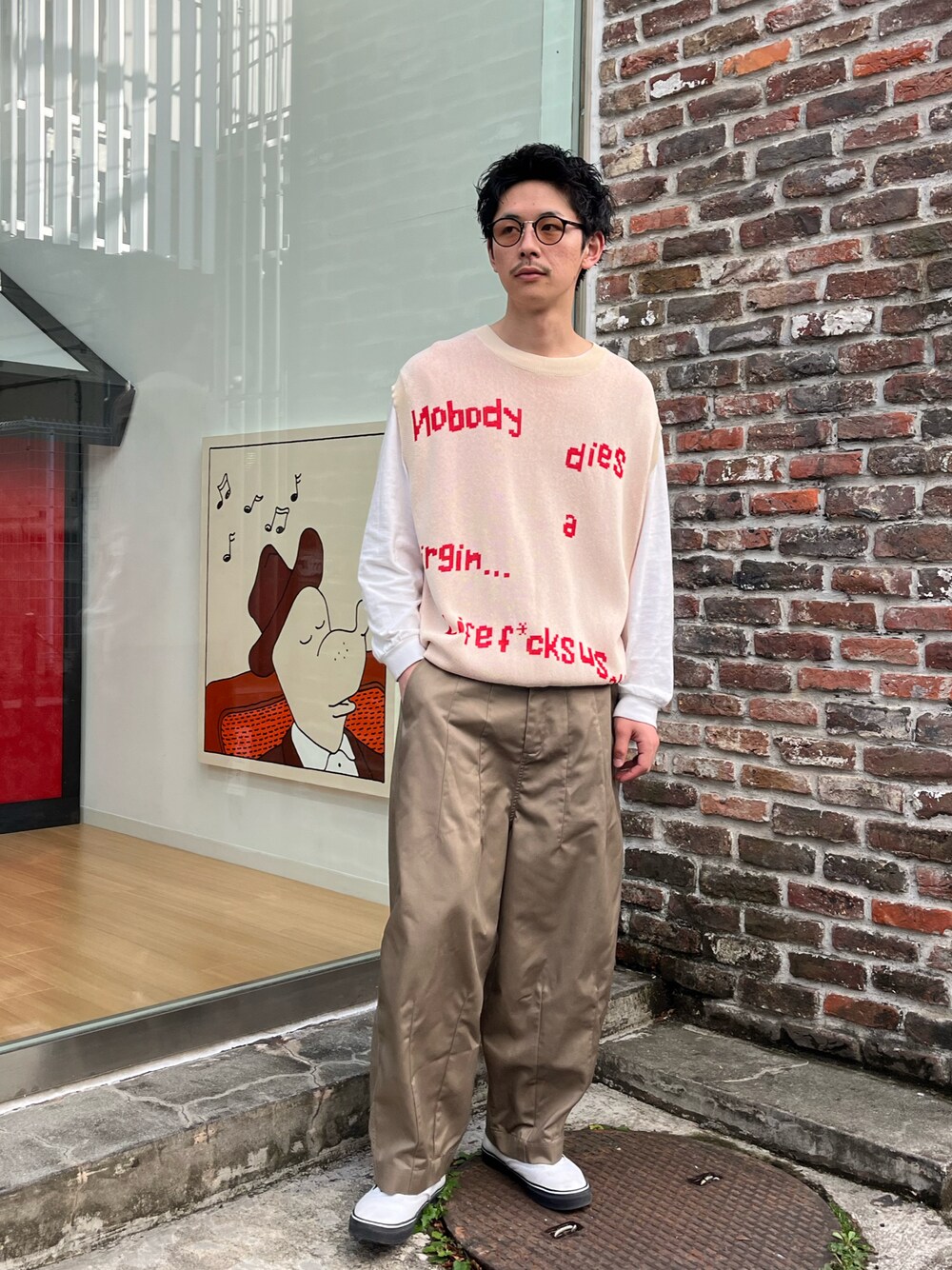 ベージュ系のベスト、ベージュ系のチノパンツを着用したメンズの春コーディネートの1枚目の写真