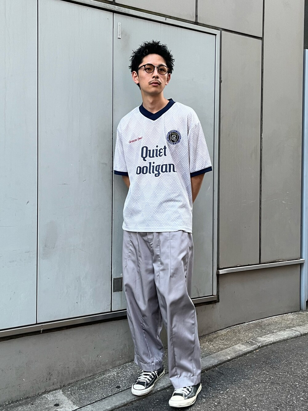 グリーン系のTシャツ/カットソー、ブラック系のチノパンツを着用したメンズの春コーディネートの1枚目の写真