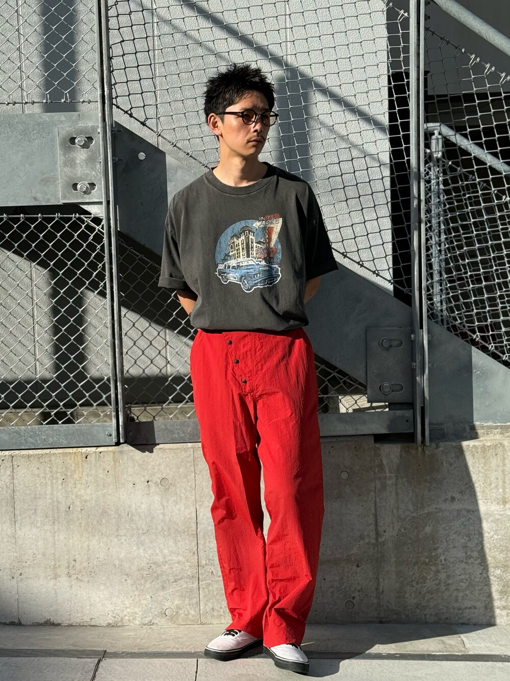 ブラック系のTシャツ/カットソー、レッド系のその他パンツを着用したメンズの春コーディネートの1枚目の写真