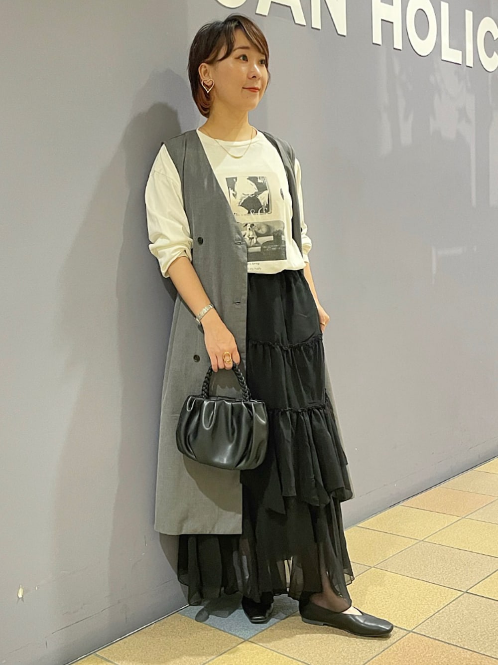 「ジレスタイル、ジレ、ジレコーデ、ロングジレ、ベストコーデ、プリントT、フォトプリント、長袖カットソー、ティアードスカート、ティアードスカートコーデ、フリルスカート、パンプスコーデ、パンプス 黒、アメリカンホリック、AMERICAN HOLIC」｜「AMERICAN HOLICの編み込みハンドルミニショルダーBAG（ショルダーバッグ、ブラック系）」を使った、ah.susuyuさん（骨格ストレート・レディース・158cm）の秋コーディネートの1枚目の写真