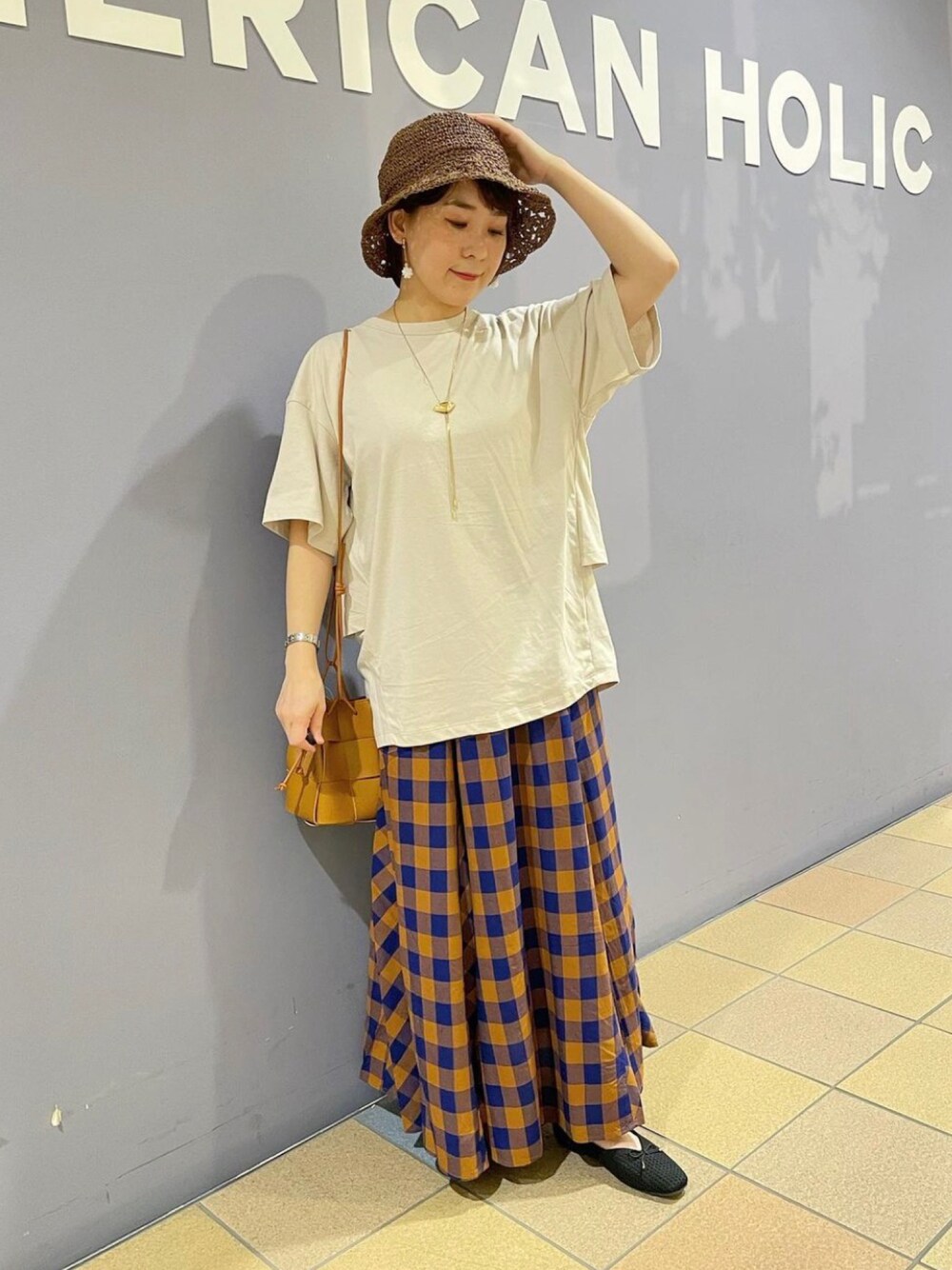 グレー系のTシャツ/カットソー、ブラウン系のショルダーバッグ、ブルー系のスカートを着用したレディースの夏コーディネートの1枚目の写真