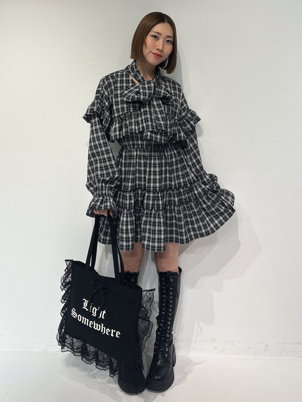 ブラック系のワンピース、ブラック系のトートバッグ、ブラック系のブーツを着用したレディースの冬コーディネートの1枚目の写真