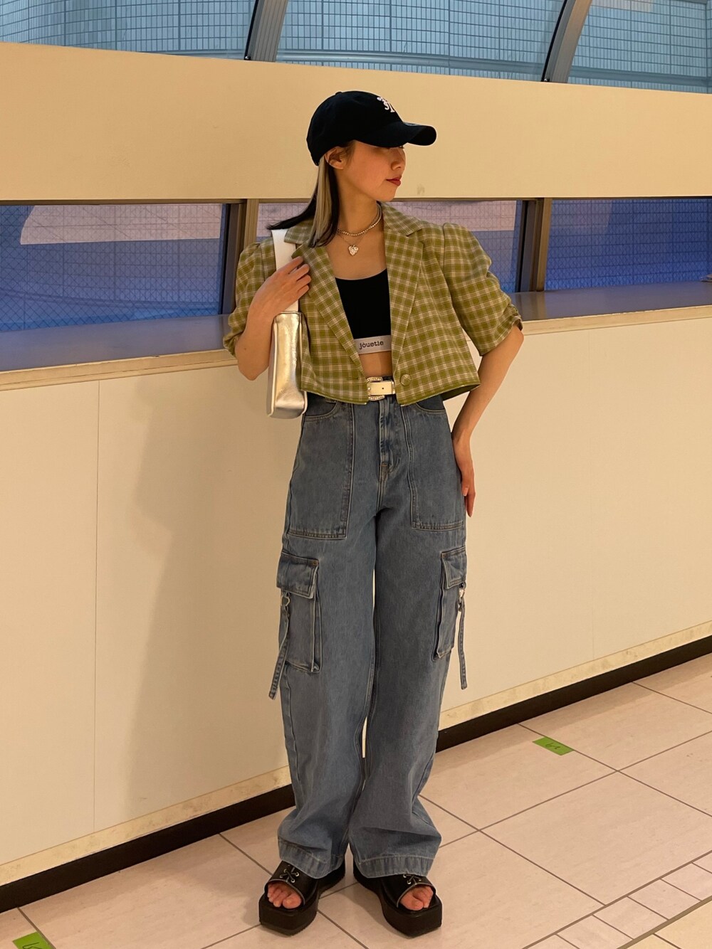 ブルー系のカーゴパンツ、グリーン系のテーラードジャケット、シルバー系のハンドバッグを着用したレディースの春コーディネートの1枚目の写真