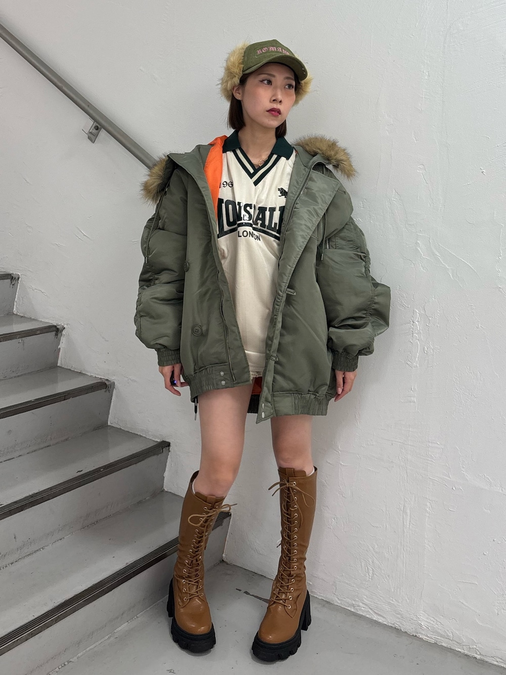 ホワイト系のTシャツ/カットソー、ホワイト系のスカート、グリーン系のブルゾンを着用したレディースの秋コーディネートの1枚目の写真