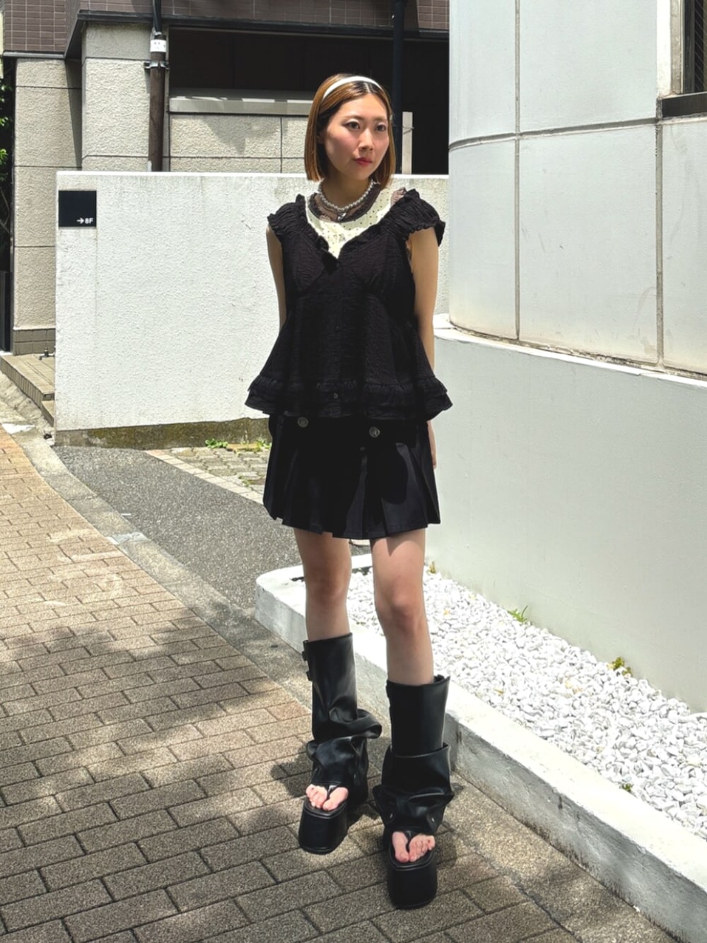 ブラック系のサンダル、ブラック系のシャツ/ブラウス、ブラック系のスカートを着用したレディースの夏コーディネートの1枚目の写真