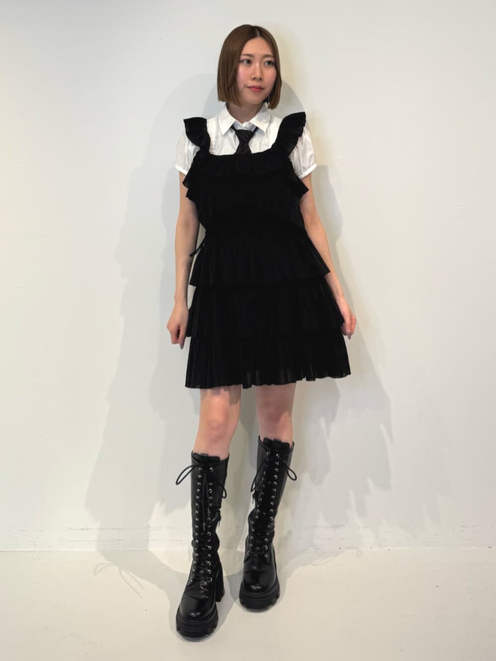 ブラック系のブーツ、ホワイト系のシャツ/ブラウス、ブラック系のネクタイを着用したレディースの春コーディネートの1枚目の写真