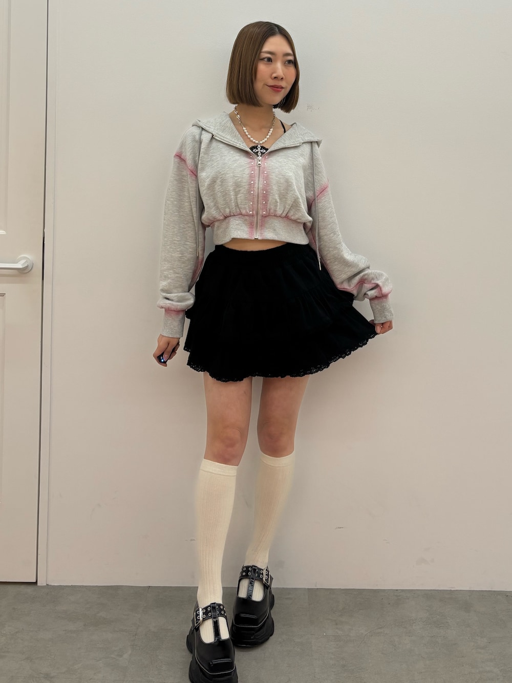 グレー系のパーカー、ブラック系のローファー、シルバー系のネックレスを着用したレディースの春コーディネートの1枚目の写真