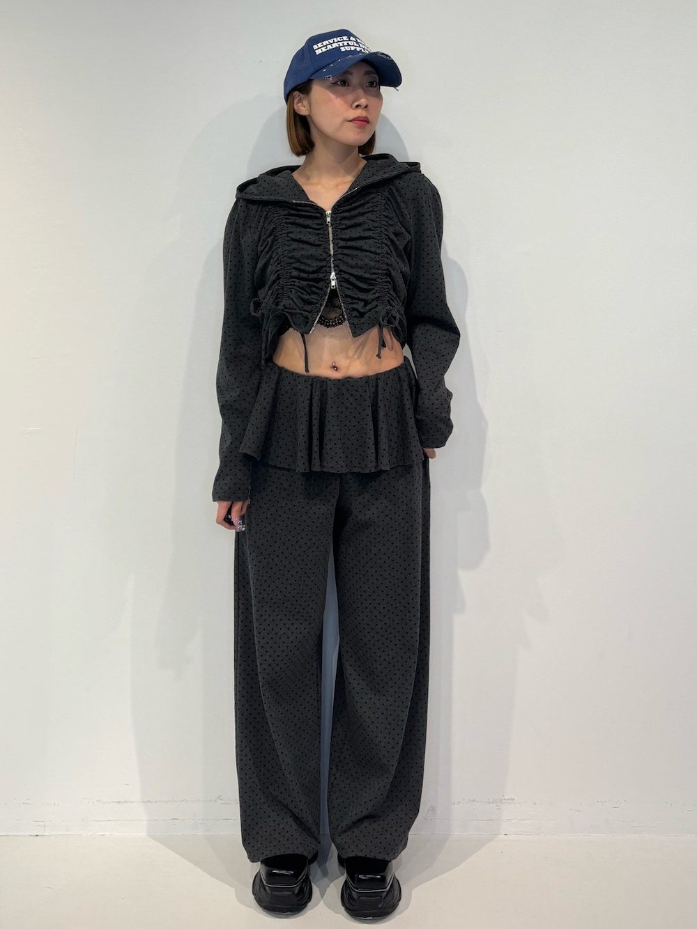 グレー系のスウェットパンツ、ブラック系のパーカー、ブラック系のローファーを着用したレディースの冬コーディネートの1枚目の写真