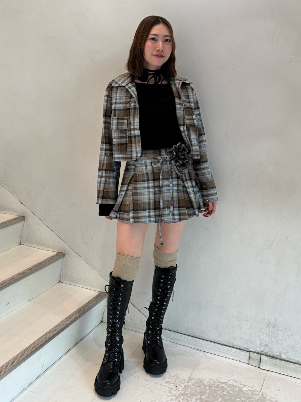 ブラウン系のスカート、ブラウン系のテーラードジャケット、ブラック系のTシャツ/カットソーを着用したレディースの冬コーディネートの1枚目の写真