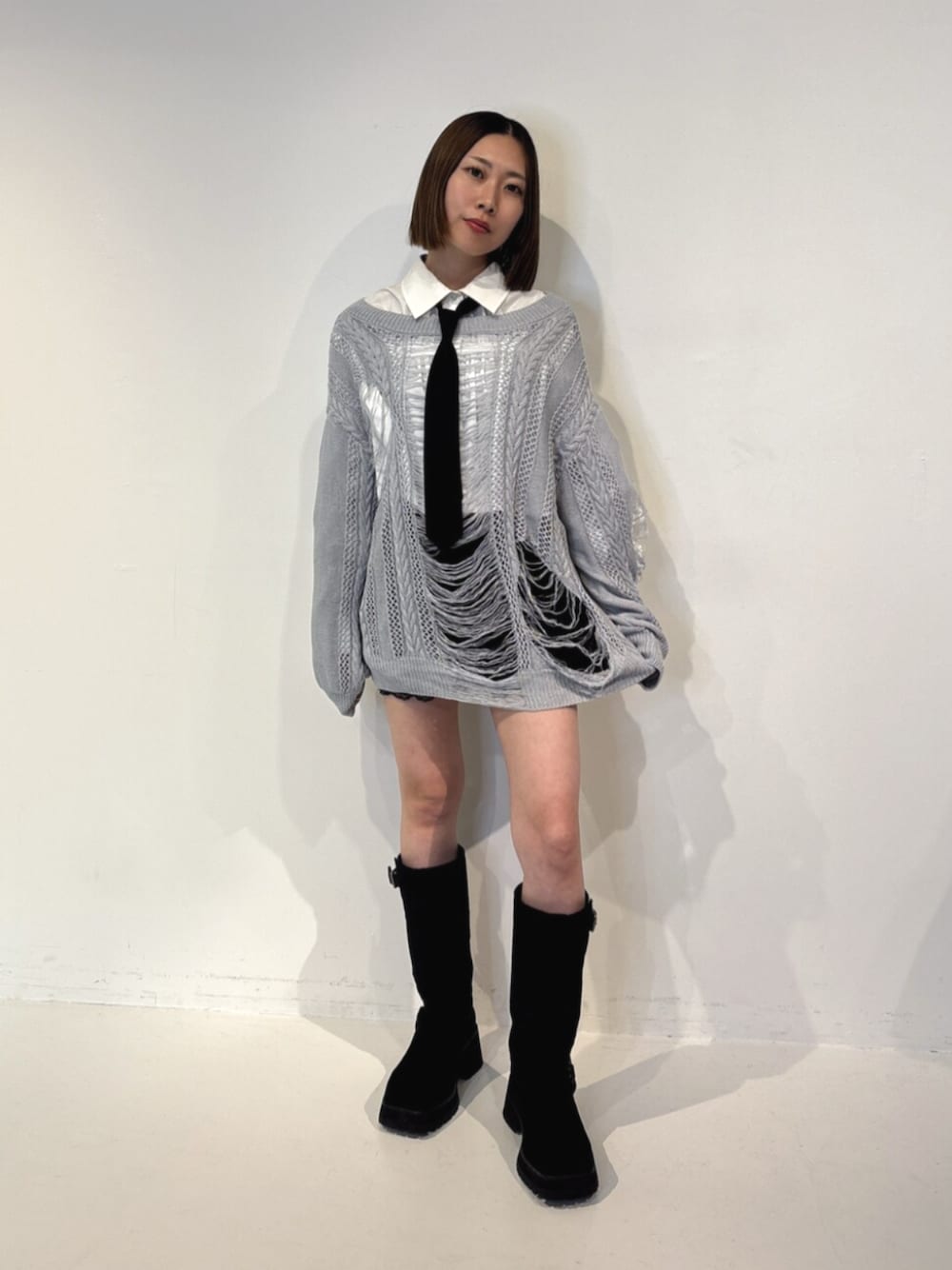 ブラック系のその他パンツ、ブラック系のブーツ、ブルー系のニット/セーターを着用したレディースの夏コーディネートの1枚目の写真