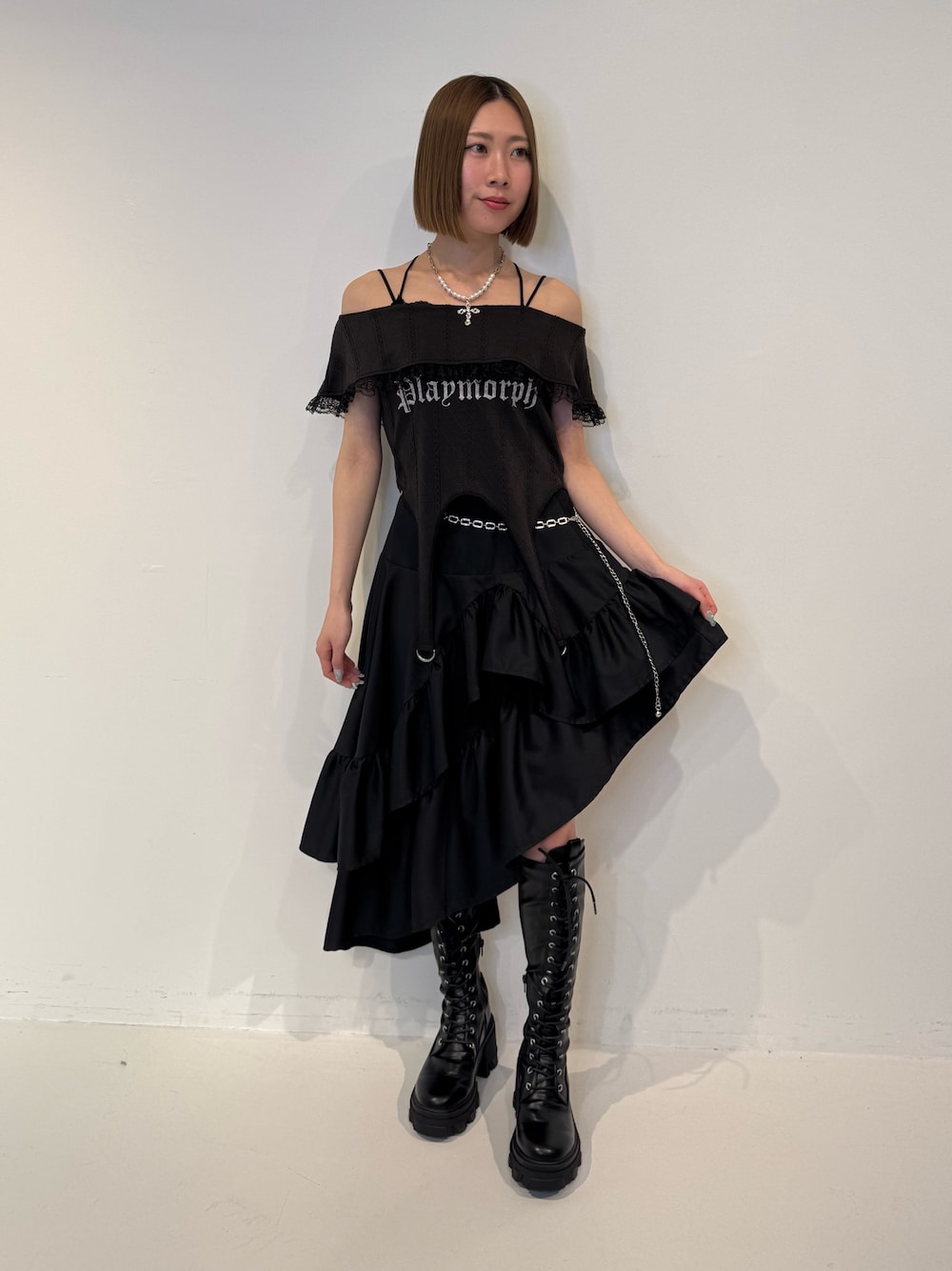 ブラック系のTシャツ/カットソー、ブラック系のスカート、ブラック系のブーツを着用したレディースの春コーディネートの1枚目の写真