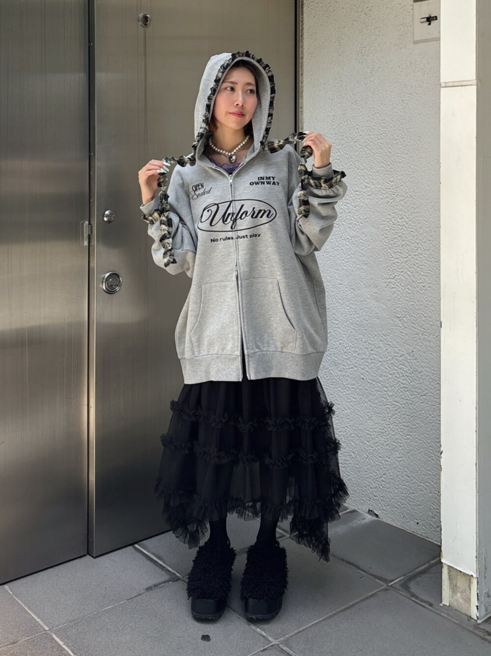 グレー系のその他トップス、ブラック系のスカート、ブラック系のサンダルを着用したレディースの夏コーディネートの1枚目の写真