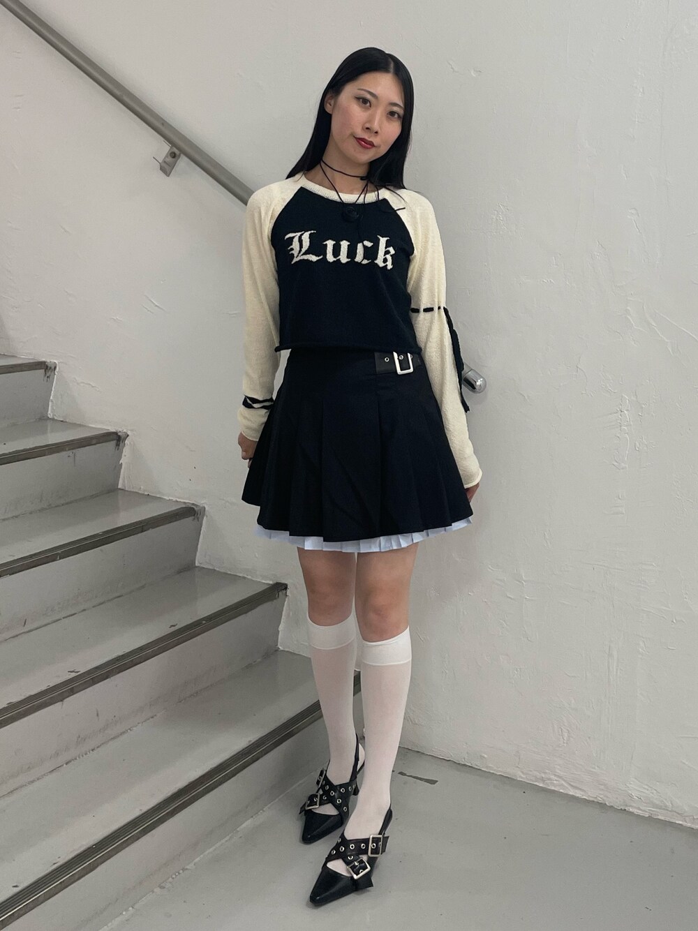 ブラック系のスカート、ブラック系のパンプス、ブラック系のニット/セーターを着用したレディースの夏コーディネートの1枚目の写真