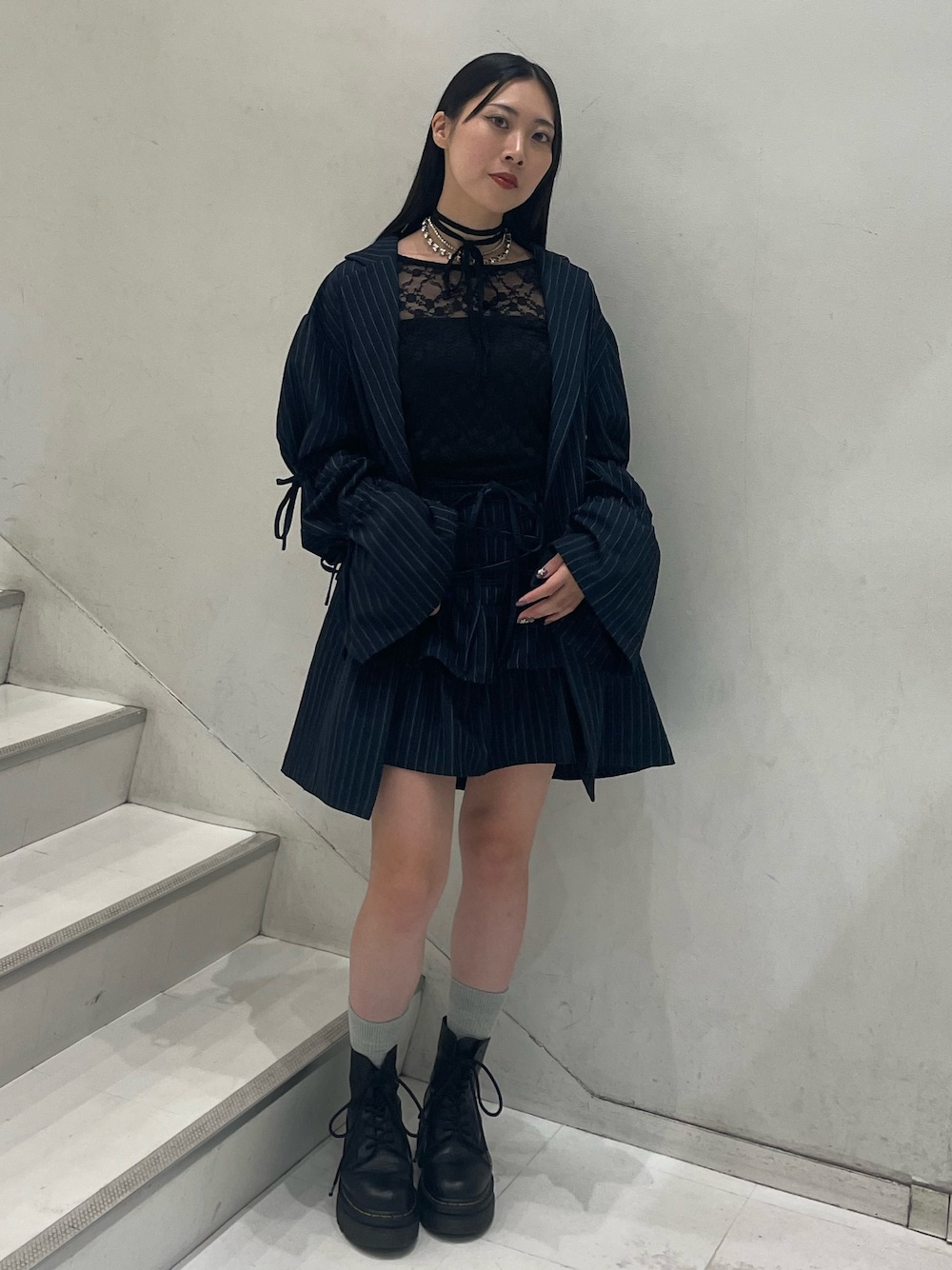 ブラック系のTシャツ/カットソー、ブルー系のテーラードジャケット、ブルー系のスカートを着用したレディースの秋コーディネートの1枚目の写真