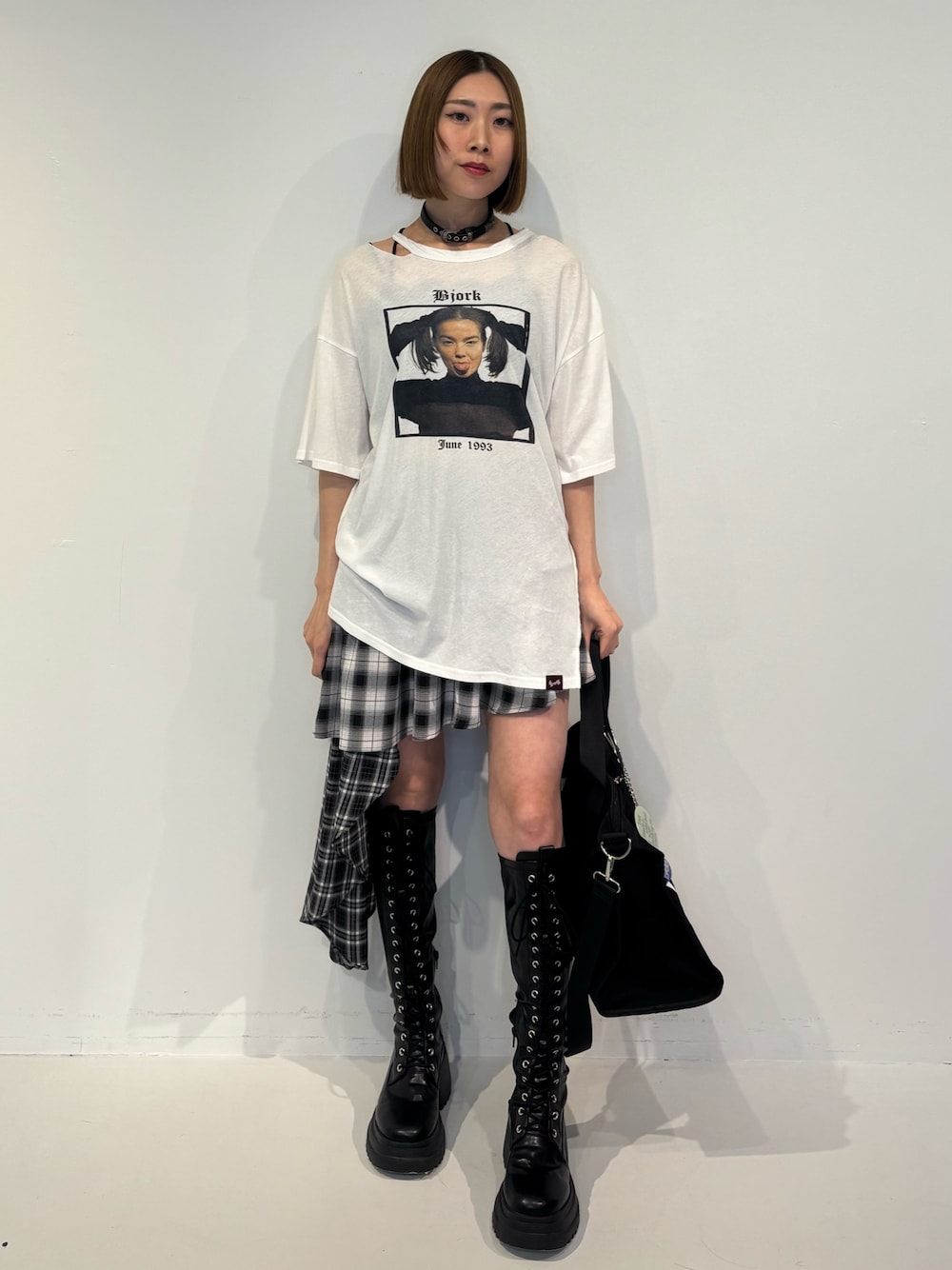 ブラック系のブーツ、ブラック系のボストンバッグ、ブラック系のスカートを着用したレディースの冬コーディネートの1枚目の写真