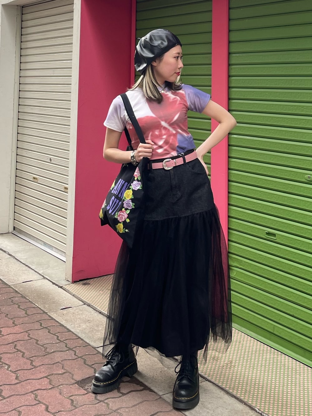 ブラック系のスカート、ブラック系のトートバッグ、パープル系のTシャツ/カットソーを着用したレディースの春コーディネートの1枚目の写真