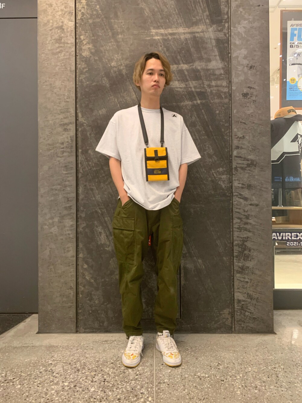 ホワイト系のTシャツ/カットソー、イエロー系のバッグ、グリーン系のカーゴパンツを着用したメンズの夏コーディネートの1枚目の写真