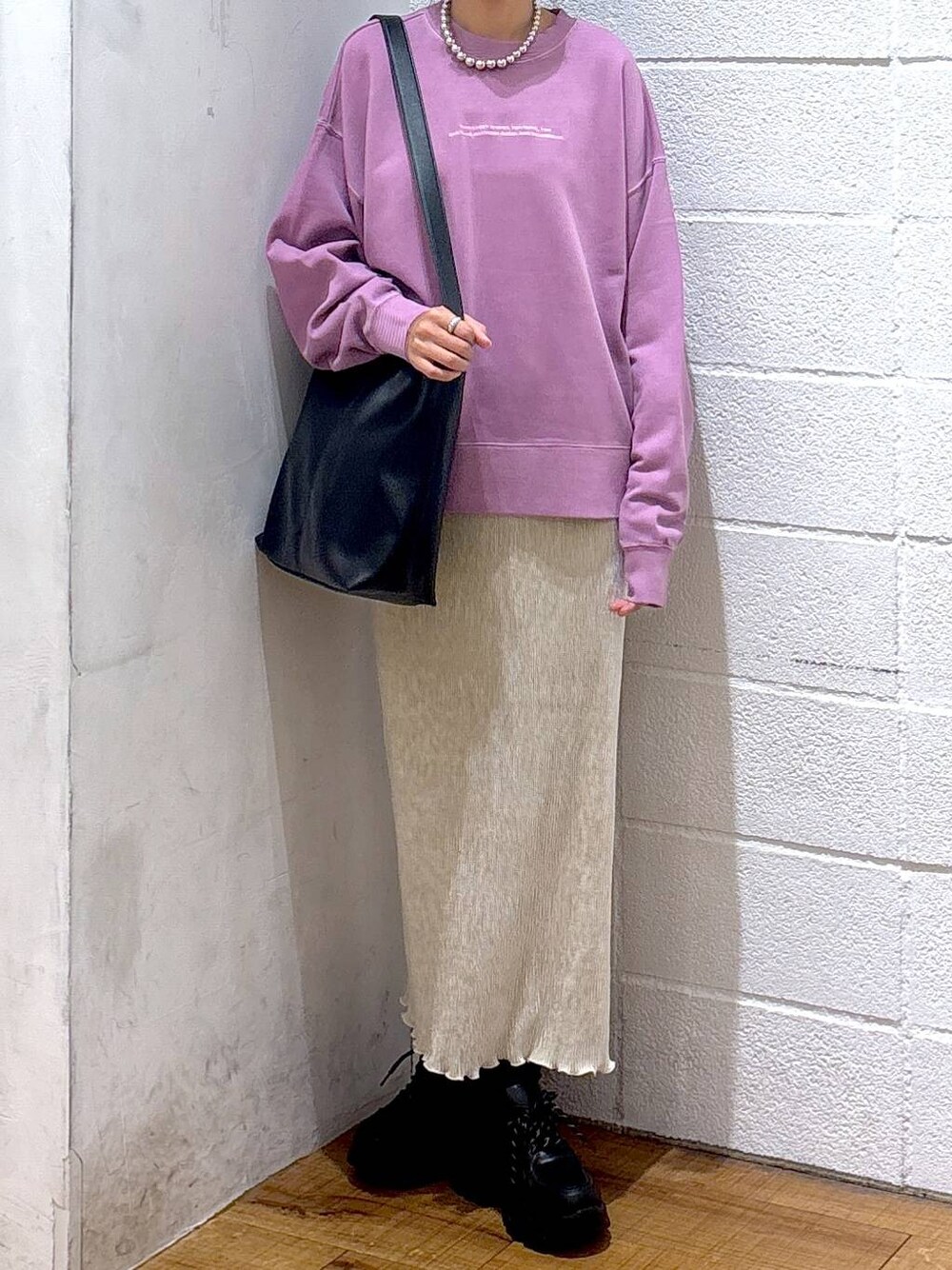 ブラック系のショルダーバッグ、パープル系のスウェット、ホワイト系のスカートを着用したレディースの秋コーディネートの1枚目の写真