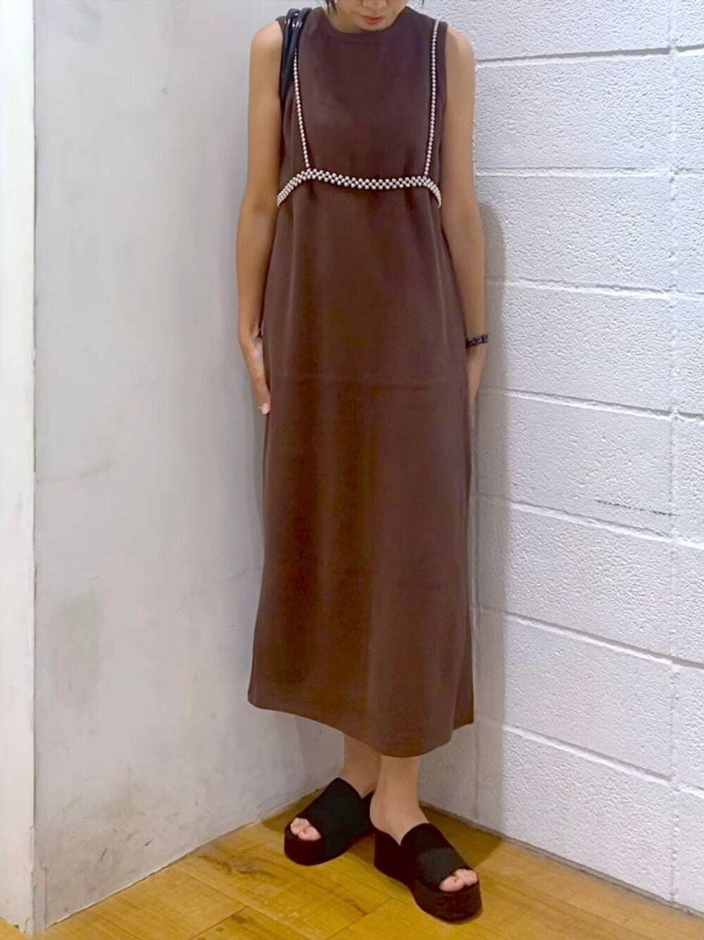 ブラック系のサンダル、ブラウン系のワンピース、ブラック系のショルダーバッグを着用したレディースの夏コーディネートの1枚目の写真