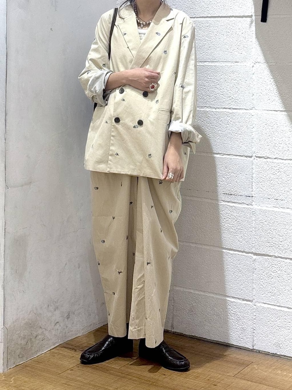 ホワイト系のタンクトップ、ブラウン系のトートバッグ、ベージュ系のその他アウターを着用したレディースの春コーディネートの1枚目の写真