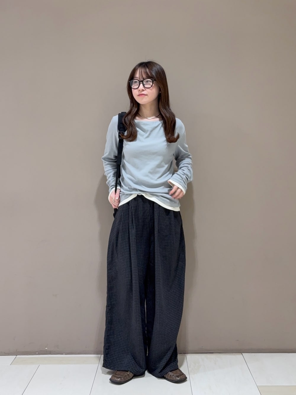 ブラウン系のローファー、グレー系のその他パンツ、ブラック系のバックパック/リュックを着用したレディースの秋コーディネートの1枚目の写真