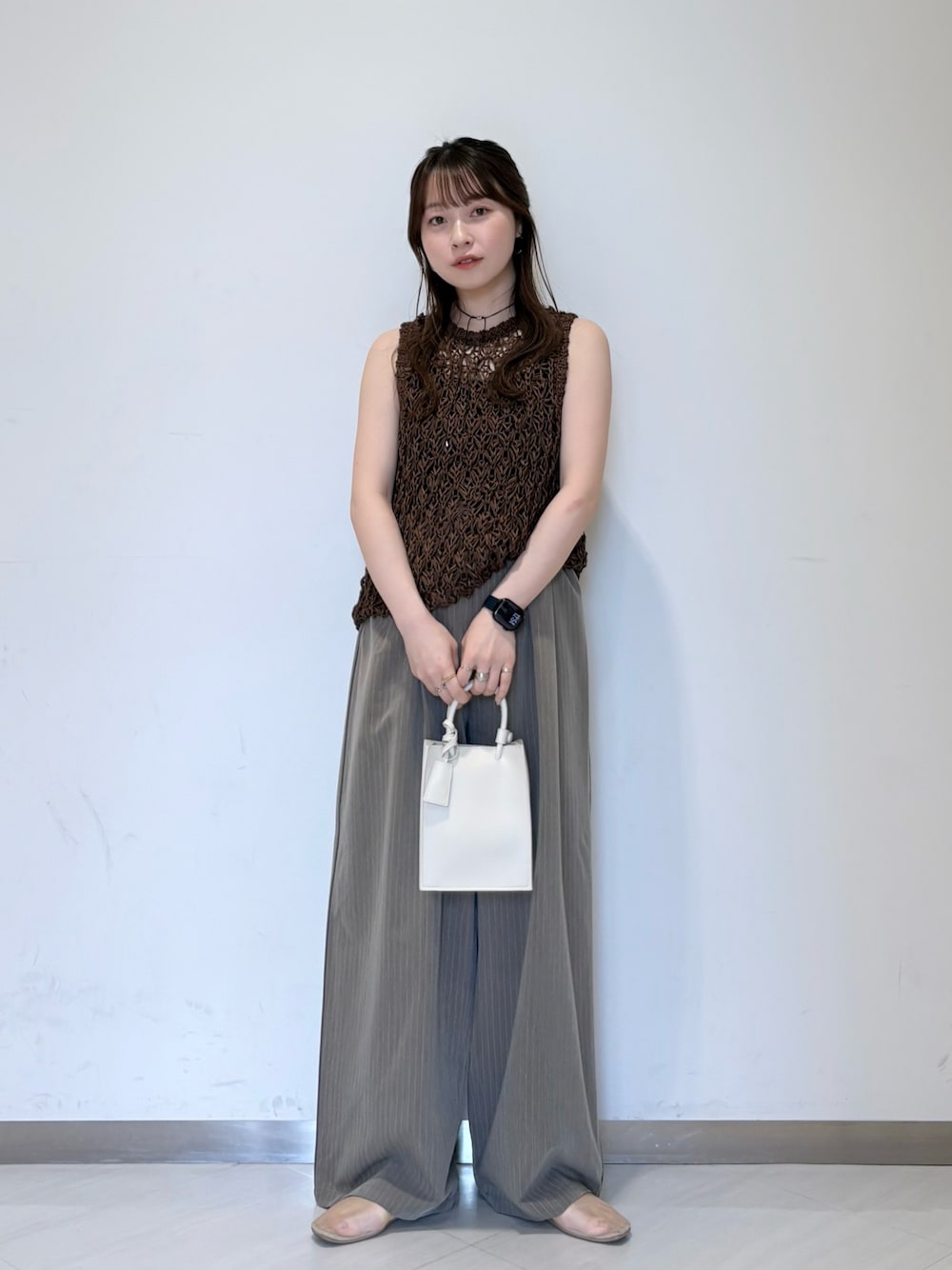 ホワイト系のニット/セーター、ブラウン系のその他パンツ、ブラック系のキャミソールを着用したレディースの春コーディネートの1枚目の写真