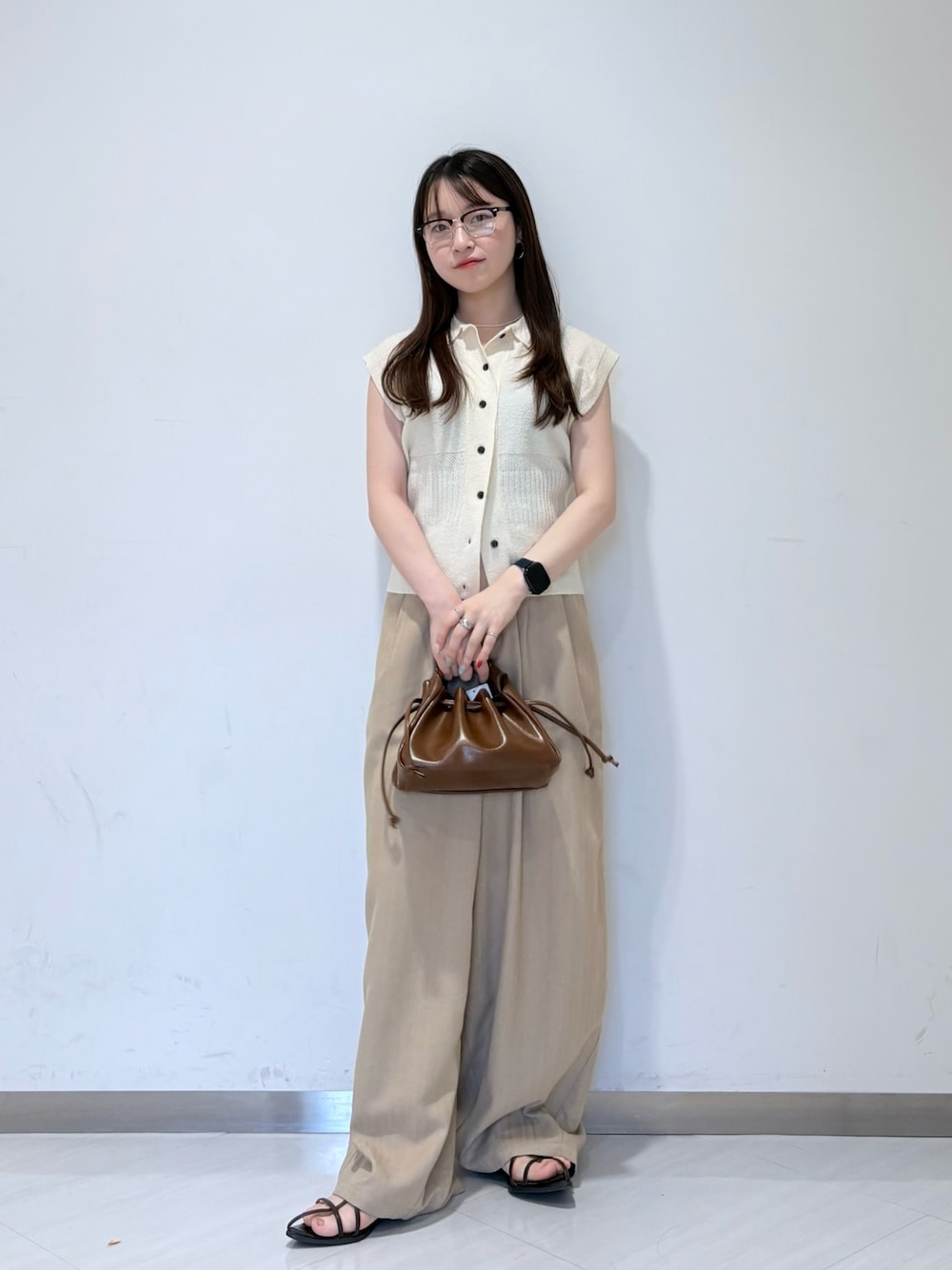 ホワイト系のニット/セーター、ベージュ系のその他パンツ、ブラウン系のハンドバッグを着用したレディースの夏コーディネートの1枚目の写真