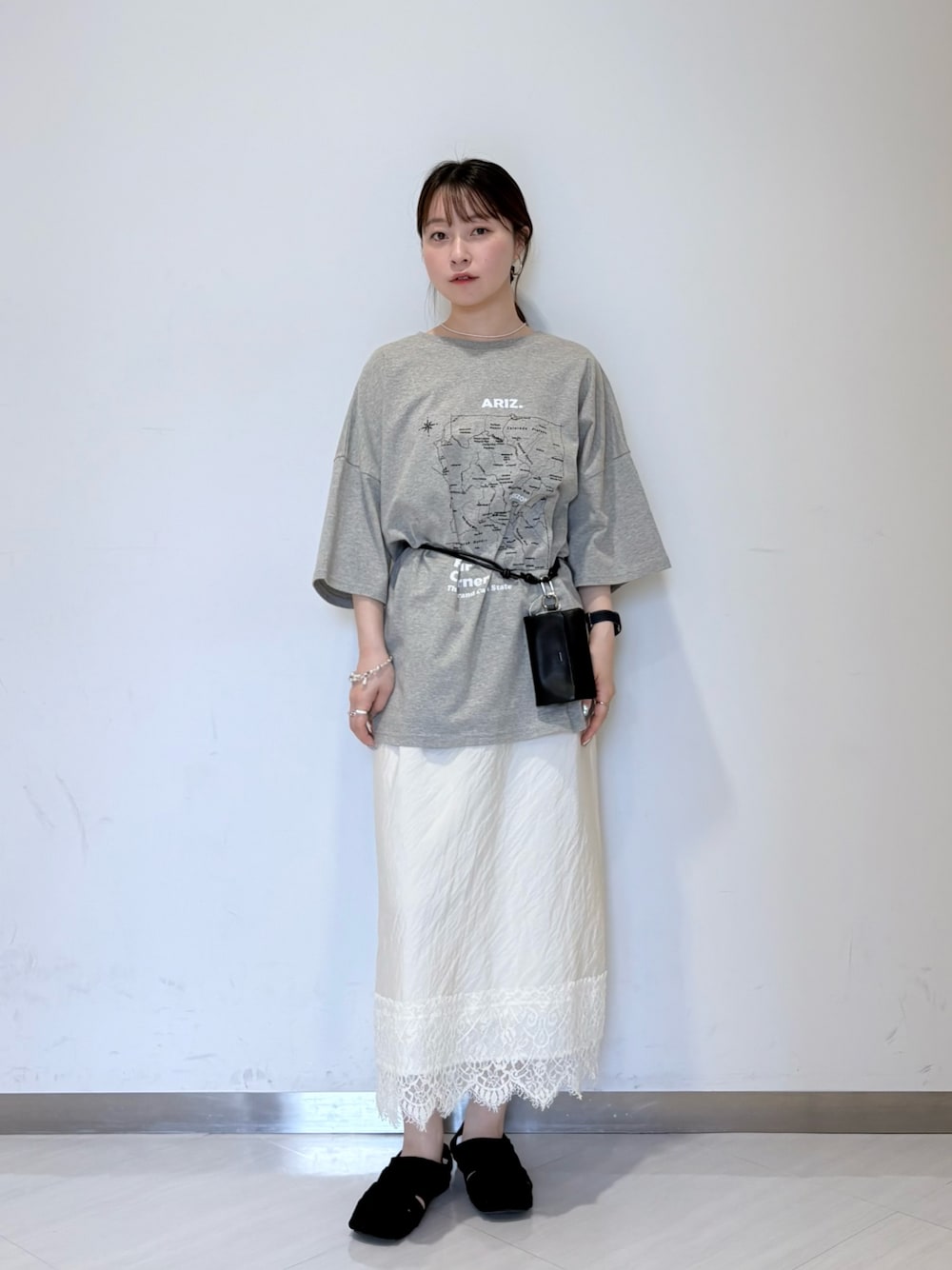 グレー系のTシャツ/カットソー、ホワイト系のスカート、ブラック系のサンダルを着用したレディースの夏コーディネートの1枚目の写真