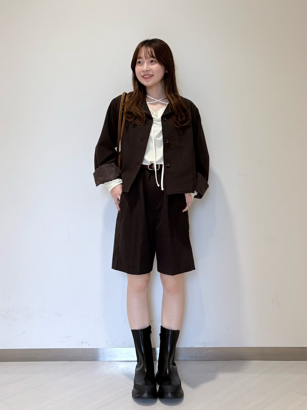 ブラウン系のその他アウター、ブラウン系のその他パンツ、ブラック系のブーツを着用したレディースの秋コーディネートの1枚目の写真