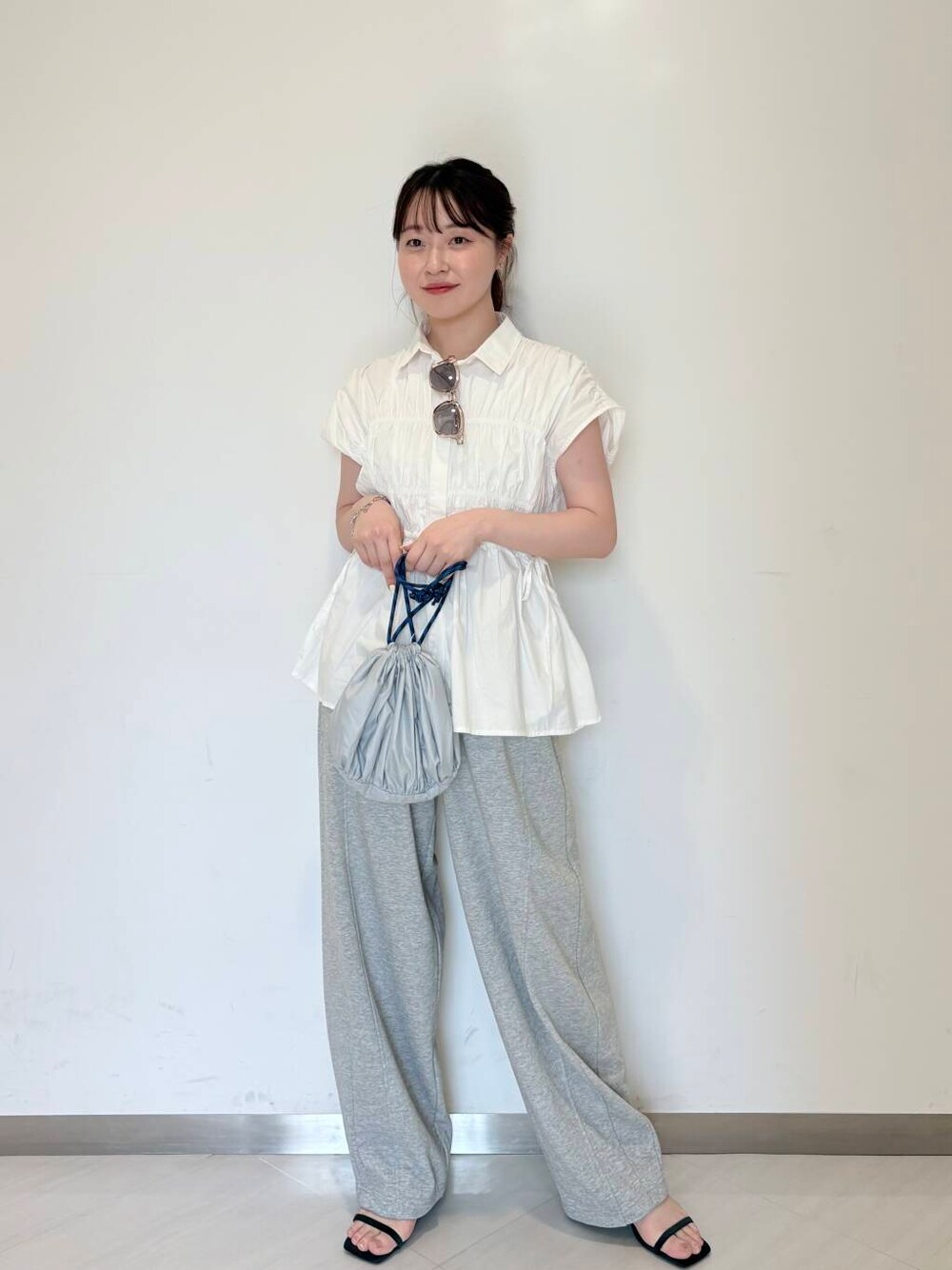 グレー系のその他パンツ、ブルー系のサンダル、ホワイト系のシャツ/ブラウスを着用したレディースの夏コーディネートの1枚目の写真