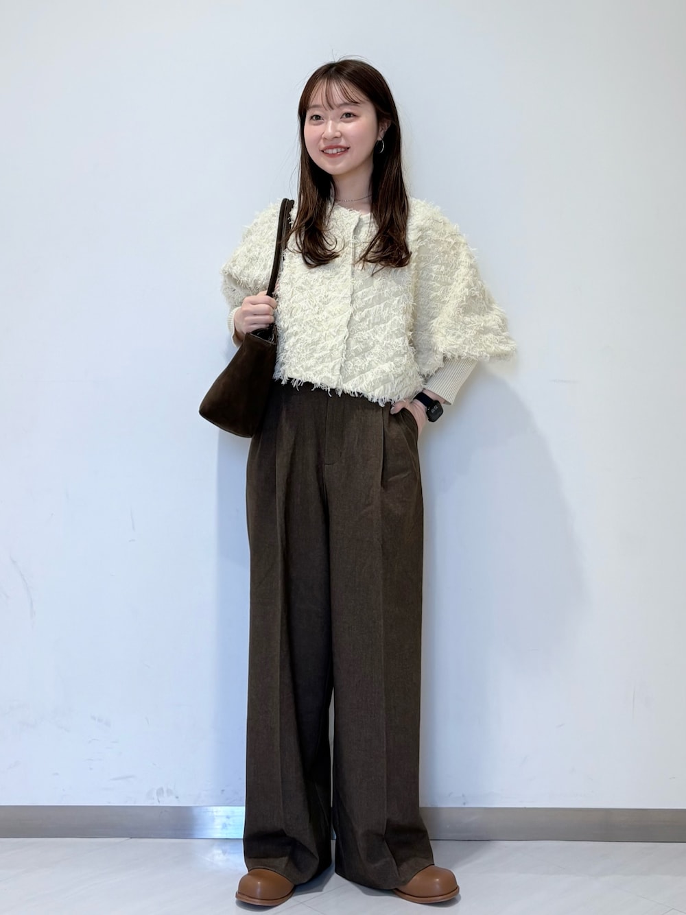 ホワイト系のカーディガン/ボレロ、ブラウン系のその他パンツ、ブラウン系のボストンバッグを着用したレディースの冬コーディネートの1枚目の写真