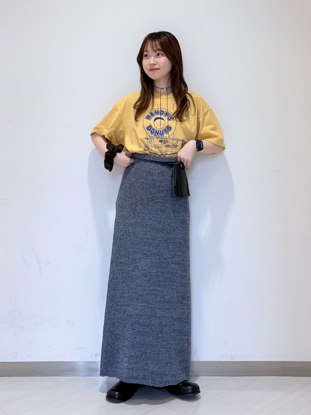 ブルー系のスカート、ブラック系のその他シューズ、イエロー系のTシャツ/カットソーを着用したレディースの春コーディネートの1枚目の写真