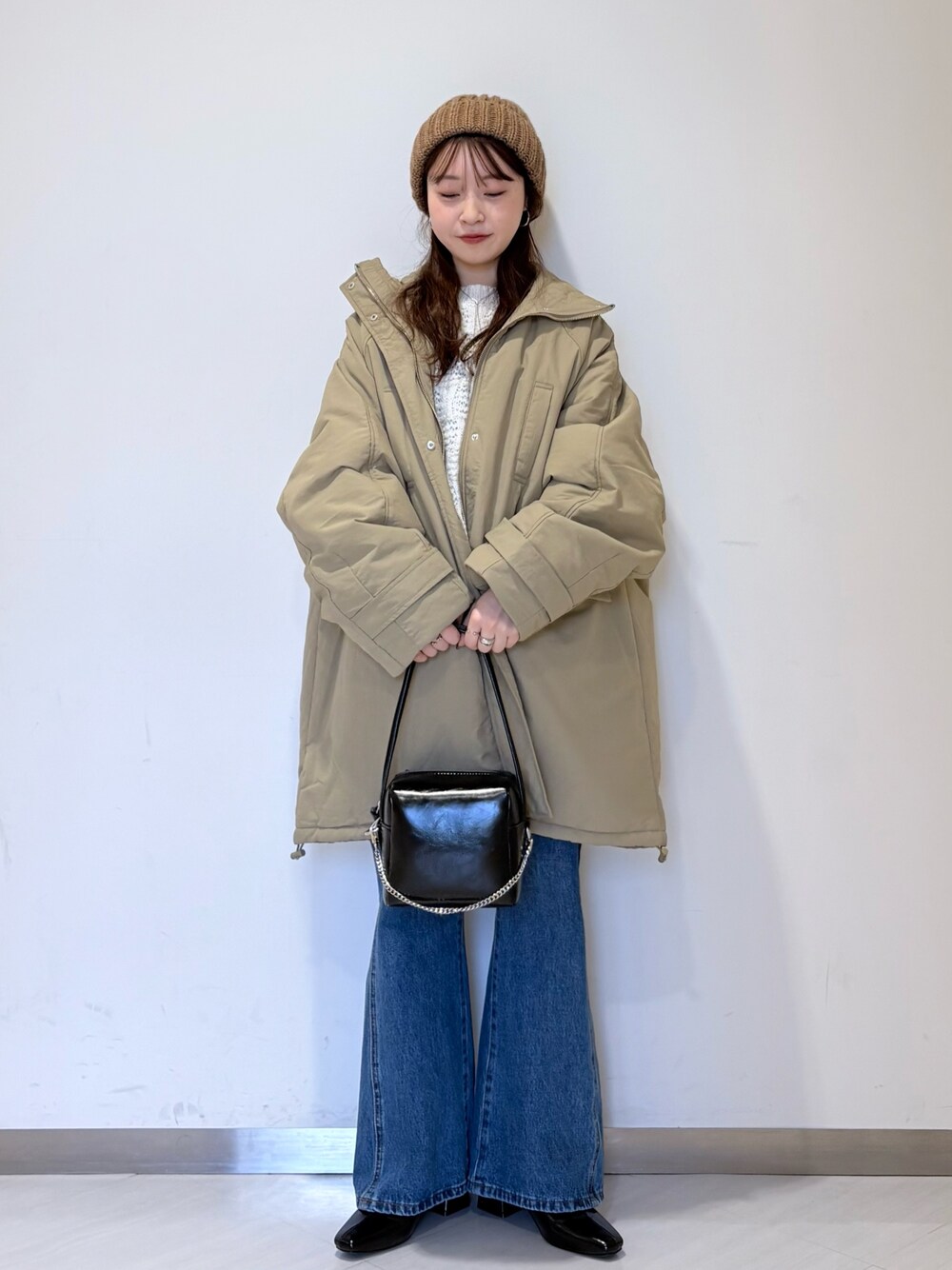 グリーン系のダウンジャケット/コート、ブルー系のデニムパンツ、ブラック系のパンプスを着用したレディースの冬コーディネートの1枚目の写真