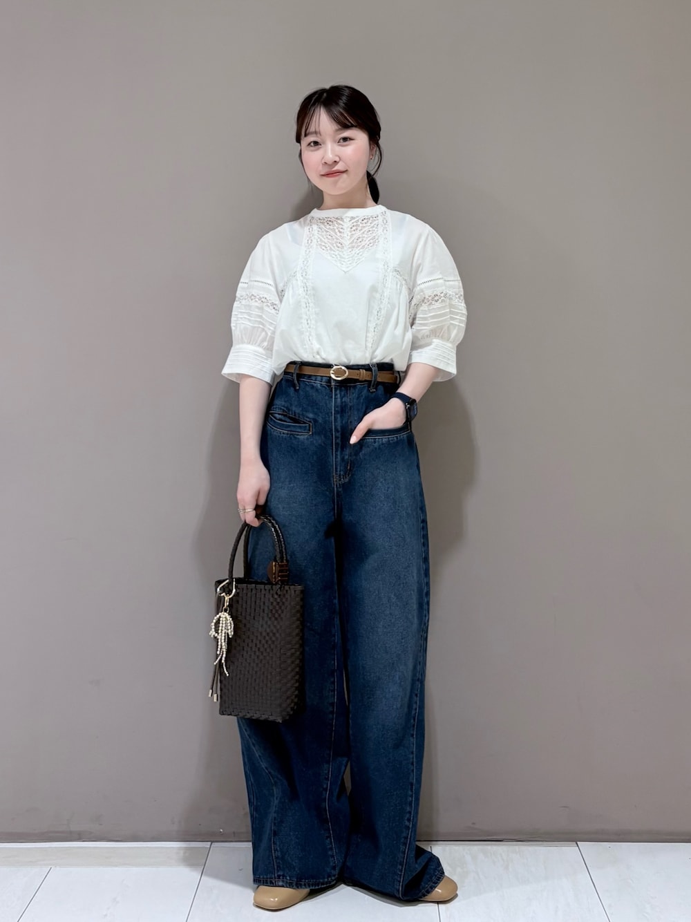イエロー系のパンプス、ブラウン系のトートバッグ、ブルー系のデニムパンツを着用したレディースの春コーディネートの1枚目の写真