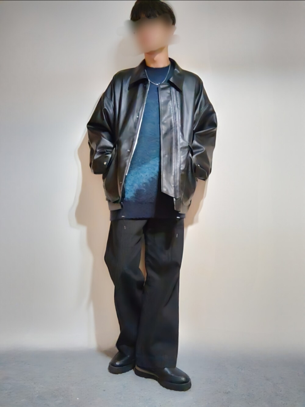 ブラック系のブルゾン、ブルー系のニット/セーター、ブラック系のデニムパンツを着用したメンズの秋コーディネートの1枚目の写真