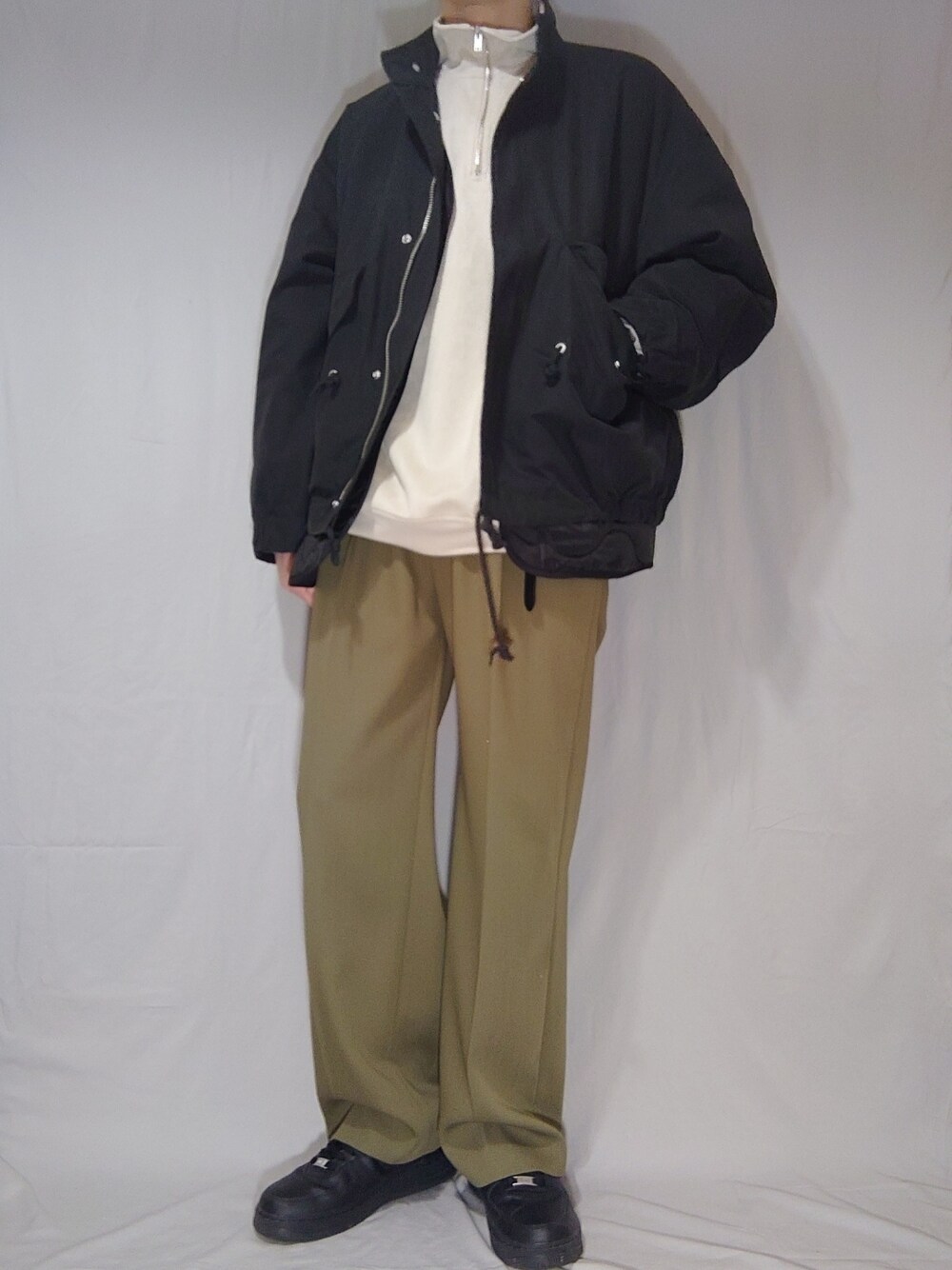 ブラック系のモッズコート、グレー系のスウェット、グリーン系のスラックスを着用したメンズの冬コーディネートの1枚目の写真